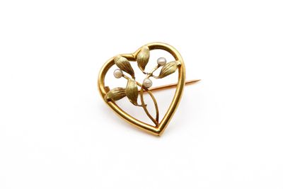 un gros plan d'une broche en forme de cœur ornée de fleurs