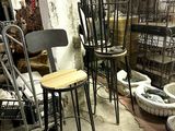 many chairs and stools that are in a room