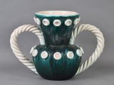 un vase vert et blanc muni d'une anse en corde