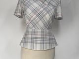 mannequin with a plaid top on a mannequin stand