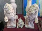 three statues of a dog and a cat on a table