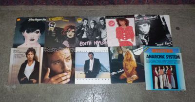 a bunch of different albums and cds on the floor