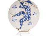 une assiette bleue et blanche sur laquelle est représentée une femme tenant un parapluie