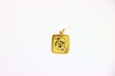 a close up of a gold pendant with a horse on it