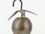 sculpture of a bird sitting on top of a metal ball on a white surface
