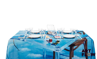 une table recouverte d'une nappe bleue sur laquelle est représenté un bateau
