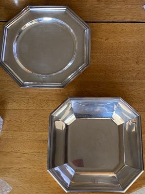 two silver plates on a wooden table next to a bag of candy
