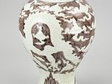 a white vase with a brown and white design on it