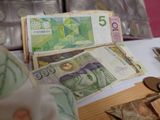 a pile of money sitting on top of a table next to coins