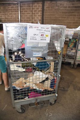 a woman standing next to a cage filled with stuffed animals