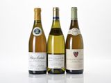 trois bouteilles de vin sont alignées sur une surface blanche