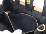a black handbag with a white cat inside of it