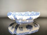 a blue and white bowl sitting on a black table