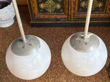 two lamps that are sitting on the floor next to a cabinet