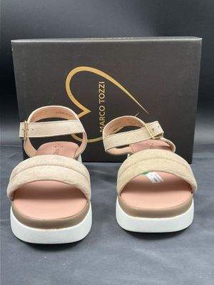 une paire de sandales pour femme en daim beige à semelles blanches
