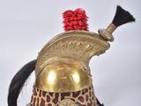 a gold helmet with a red pom pom on top of it