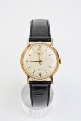 un gros plan d'une montre sur une surface blanche avec un fond blanc