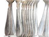 a lot of silver spoons and spoons on the table