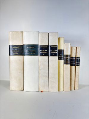 plusieurs livres sont alignés sur une surface blanche