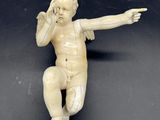 une petite figurine représentant un bébé assis sur une surface noire