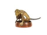 une figurine en bronze représentant un singe tenant un couteau