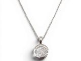 un gros plan d'un collier en argent sur fond blanc