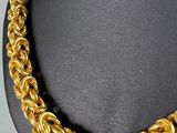a close up of a gold chain necklace on a mannequin