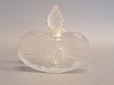 un objet en verre transparent en forme de cœur posé sur une surface blanche