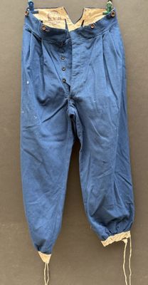 an old pair of blue pants hanging on a wall