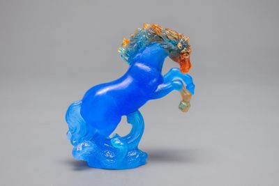 a blue glass horse that is standing on its hind legs