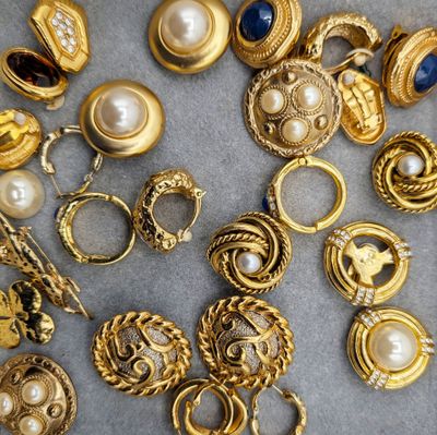 some gold rings and rings with pearls on a gray surface