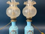 paire de lampes anciennes en verre bleu, ornées de finitions dorées, posées sur des socles en bois