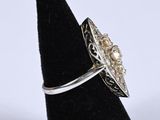 a close up of a silver ring with pearls on it