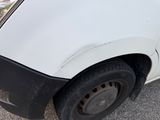 a white van with a black rim parked in a parking lot