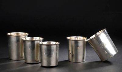 quatre tasses en argent posées les unes à côté des autres sur une table