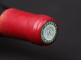 a close up of a red wine bottle with a green label