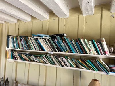 une étagère remplie de livres accrochée au mur d'une pièce
