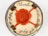 a red seal on top of a white button