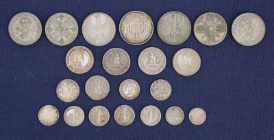 an assortment of silver coins on a blue cloth