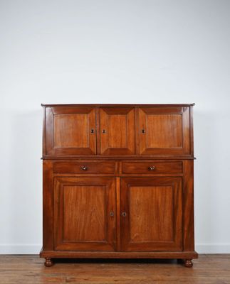 une vieille armoire en bois dans une pièce aux murs blancs