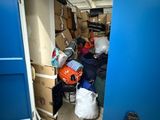 a blue door that is open to a room full of boxes