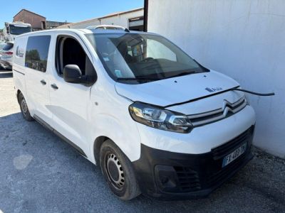 La camionnette blanche est garée devant un mur blanc.