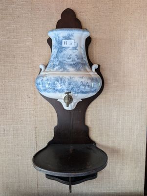 un vase bleu et blanc posé sur une étagère fixée au mur