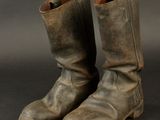 an old pair of brown boots sitting on top of a black surface