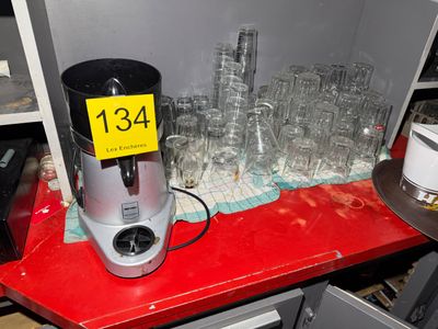 a red counter with a blender and glasses on it