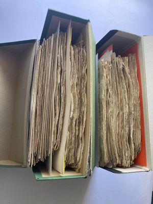 deux boîtes ouvertes contenant des papiers, posées sur une table