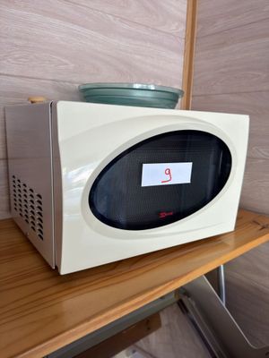 un micro-ondes posé sur une étagère en bois dans une pièce
