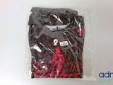 a black t - shirt in a plastic bag on a white surface