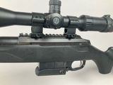 the rifle is sitting on a white surface with a red dot on it
