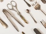 a lot of silver spoons and forks on the table